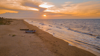 Sunset Over the Tranquil Beach in La Guajira, Colombia with Traditional Fishing Boat