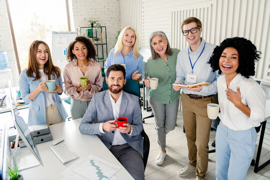 Diverse colleagues enjoying a casual team gathering in a shared office workspace.
