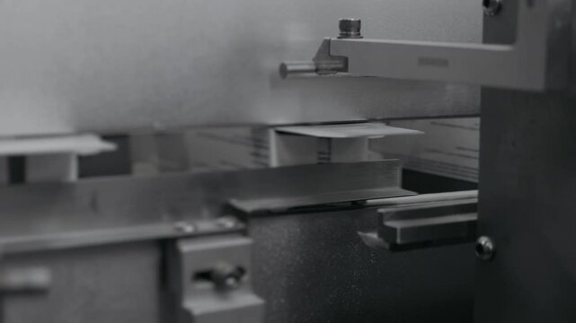 Automated case packer sealing cardboard boxes on a factory conveyor line.