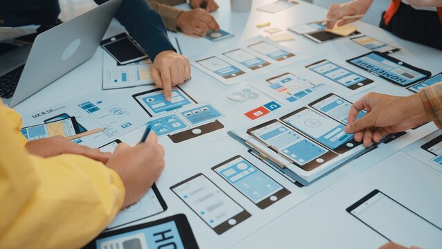 A dynamic team collaborates on mobile app design, utilizing wireframes and prototypes in a creative workspace. Enthusiastic participants engage in brainstorming sessions. SACTR