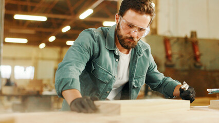 Carpenter, wood and blow dust with project, process or manufacturing furniture. Woodwork, man and remove sawdust shavings for hobby craftsman in construction industry or diy renovations product