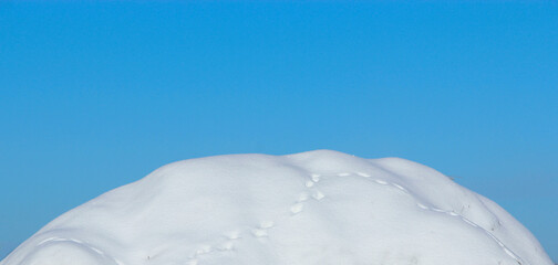 Winter landscape. Snowy hill against blue sky. Frosty weather