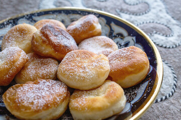 Homemade golden fried dough pastries with powdered sugar