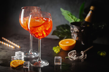 Aperol spritz cocktail in glass with fresh orange on dark background