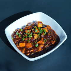 Mapo Tofu served in a bowl with a colorful garnish, mapo doufu, spicy tofu dish with minced meat, garlic, chili, and Sichuan pepper, chinese cuisine mapo tofu, soft tofu