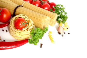 On a white background lie spaghetti and macaroni in the form of a nest with vegetables