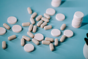 Various types of tablets and capsules arranged on a light blue background during a medication preparation session