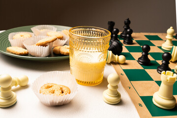 Cookies and milk chess night on white tablecloth