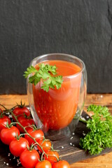 One glass with tomato juice stands on the table.