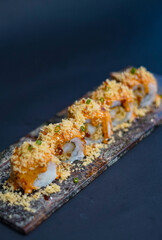 Sushi, japanese food, served on a wooden slate, sushi roll with salmon, cheese, caviar, shrimps, avocado, uramaki, California roll, Tempura roll, makizushi, Kappa Maki, Makizushi