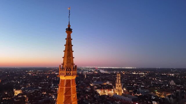 Explore Brugge's stunning aerial view showcasing its iconic architecture and serene twilight skyline over Belgium's historic city