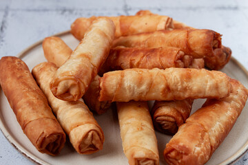 fried spring rolls with cheese, on a plate, with cream sauce, no people,