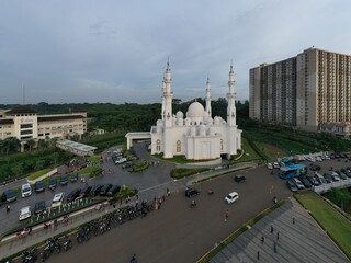  Masjid At Thohir Depok April 26, 2022 - The mosque is a beautiful white building with a large dome and several smaller domes. It is located in a residential area and is surrounded by trees