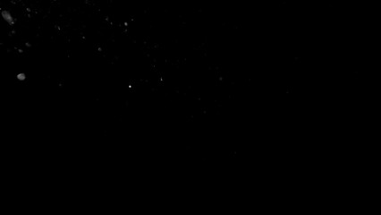 Freeze motion of dust particles flying , isolated on black background