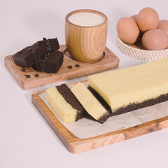Cheese brownies and pieces of chocolate brownies made from eggs and fresh milk on a wooden tray