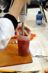 chef batiendo alimentos e ingredientes con la batidora eléctrica para hacer receta