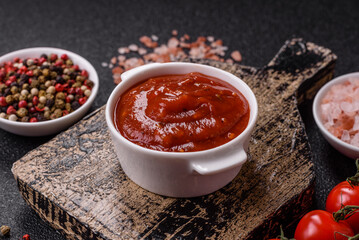 Red sauce or ketchup with salt and spices in ceramic sauce boat