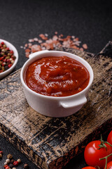 Red sauce or ketchup with salt and spices in ceramic sauce boat