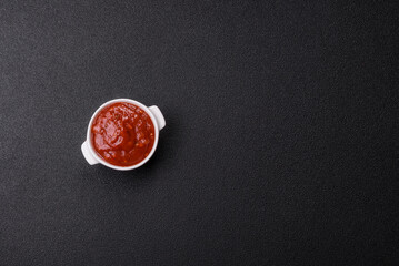 Red sauce or ketchup with salt and spices in ceramic sauce boat