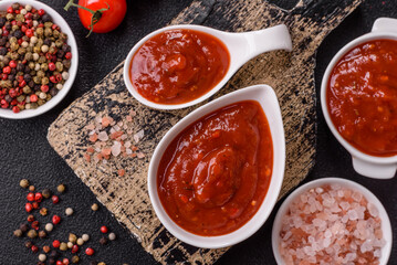Red sauce or ketchup with salt and spices in ceramic sauce boat