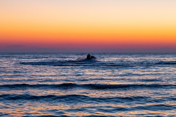 Thrilling jet ski ride on the ocean under a stunning sunset, where adventure meets the serene beauty of nature.