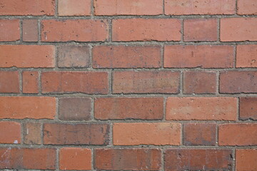 A brick wall with a red brick color
