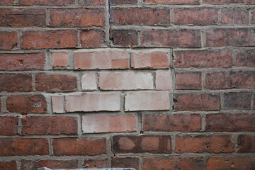 Naklejka premium A brick wall with patching bricks