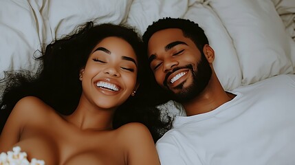 Happy couple lying in bed, smiling.