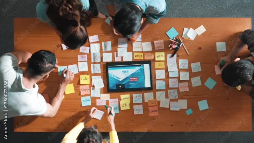 Poster top down view of programmer brainstorming and planning about web design while looking at tablet wire