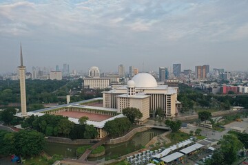 Aerial view of Istiqlal Mosque. It is the largest mosque in Southeast Asia and noise cloud with Jakarta cityscape. JAKARTA - Indonesia. May 16, 2021