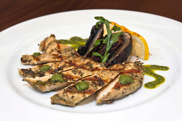 Chicken breast with Portobello mushrooms and chimichurri sauce on a wooden table