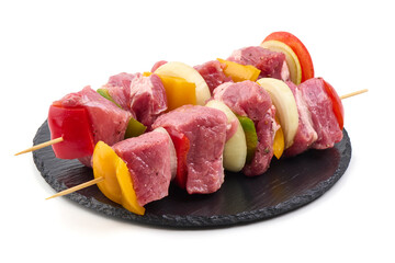 Raw Pork Skewers with Vegetables on Black Slate, Isolated on White Background.