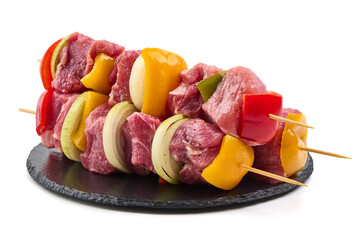 Raw Pork Skewers with Vegetables on Black Slate, Isolated on White Background.