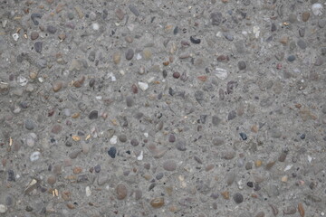 A grey stone surface with many small rocks scattered across it