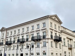 view of a Warsaw building with statues and balconies on a cloudy winter day
