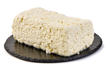 Fresh homemade cottage cheese on a black slate plate, isolated on white background.