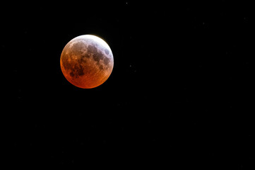 Blood moon tinged red with a little white as its approaching full of Eclipse