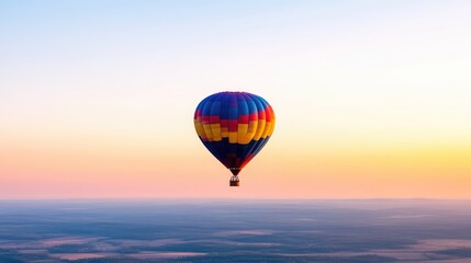 Fototapeta premium Colorful hot air balloon soaring above a landscape at sunrise