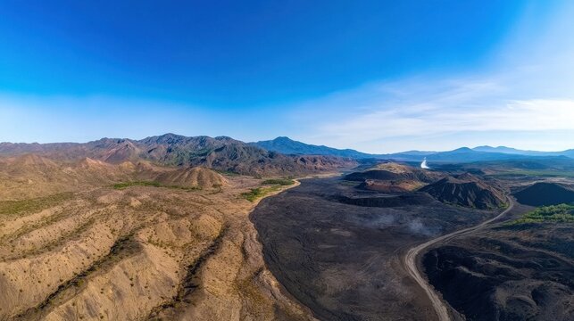 Expansive aerial view of arid desert landscape with mountains and blue sky