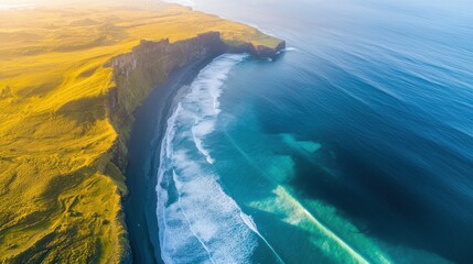 Fototapeta premium Aerial view of rugged coastline with cliffs and ocean waves in golden light