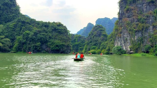 Trang An River Ninh Binh and Bai Dinh Mountain ranges in Vietnam only 3 hours drive from Hanoi. Beautiful winding river and large rising mountains. boats going through the caves in the river