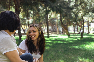 Fototapeta premium Two friends enjoying a sunny day in the park while sharing laughter and stories