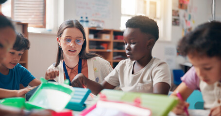 Writing, education and educator helping children in classroom for language development, learning or growth. Notebook, advice and woman teacher with kid students for lesson at elementary school.