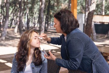 Outdoor makeup session with two women in a park during daytime
