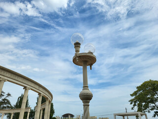 Kerch Russia 09 12 2024 Round transparent street lights against a blue sky with feathery clouds near the colonnade