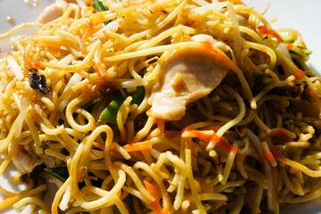 Chinesisches Essen mit gebrannten Nudeln, H&auml;hnchenfleisch und Gem&uuml;se auf Teller