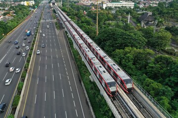 Aerial view of an LRT train parked adjacent to the toll road