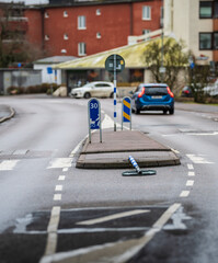 road with white lane markings and fallen blue and white striped pole.