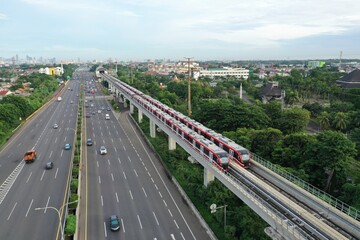 Aerial view of an LRT train parked adjacent to the toll road