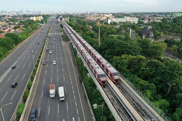 Aerial view of an LRT train parked adjacent to the toll road